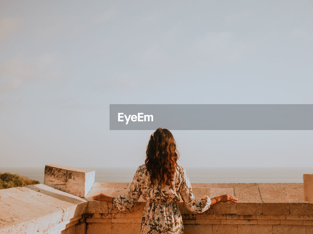 Rear view of woman looking at sea against sky