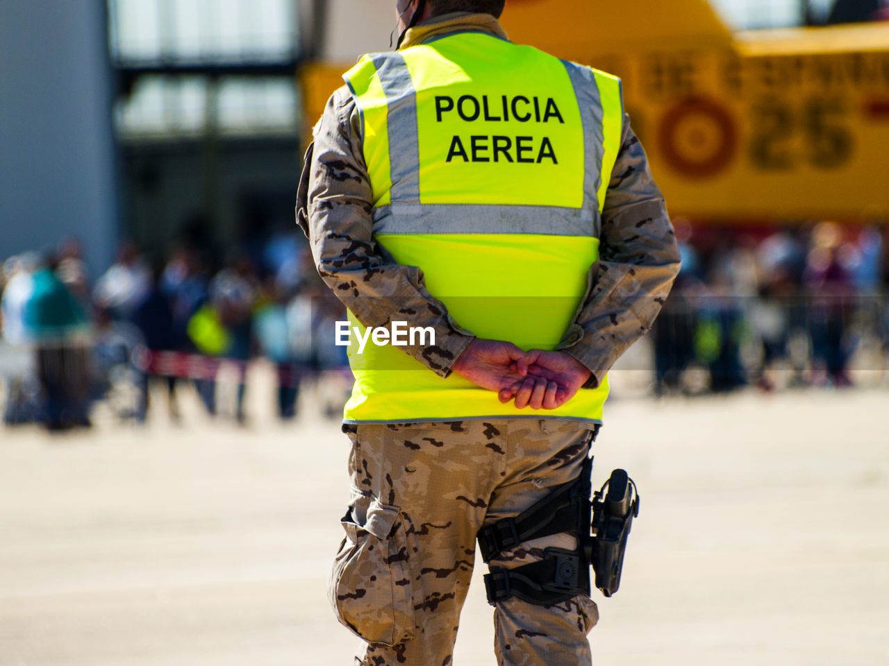 MIDSECTION OF MAN STANDING WITH TEXT ON YELLOW BACKGROUND