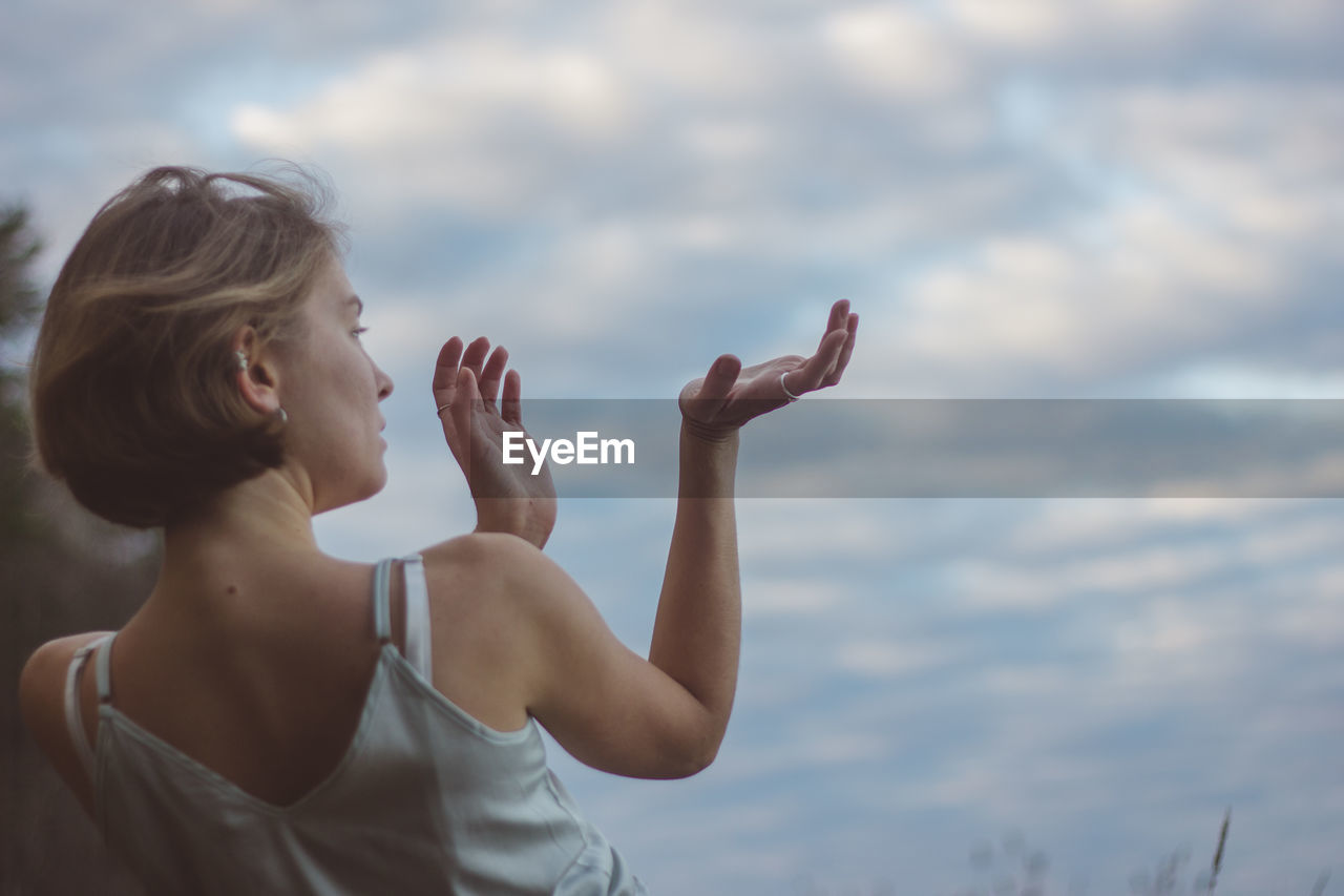 SIDE VIEW OF WOMAN AGAINST SKY