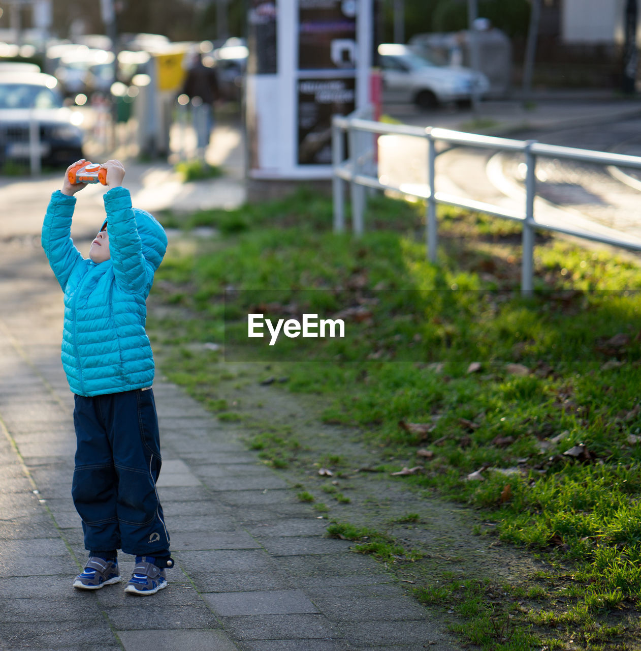 Full length of boy holding toy on footpath