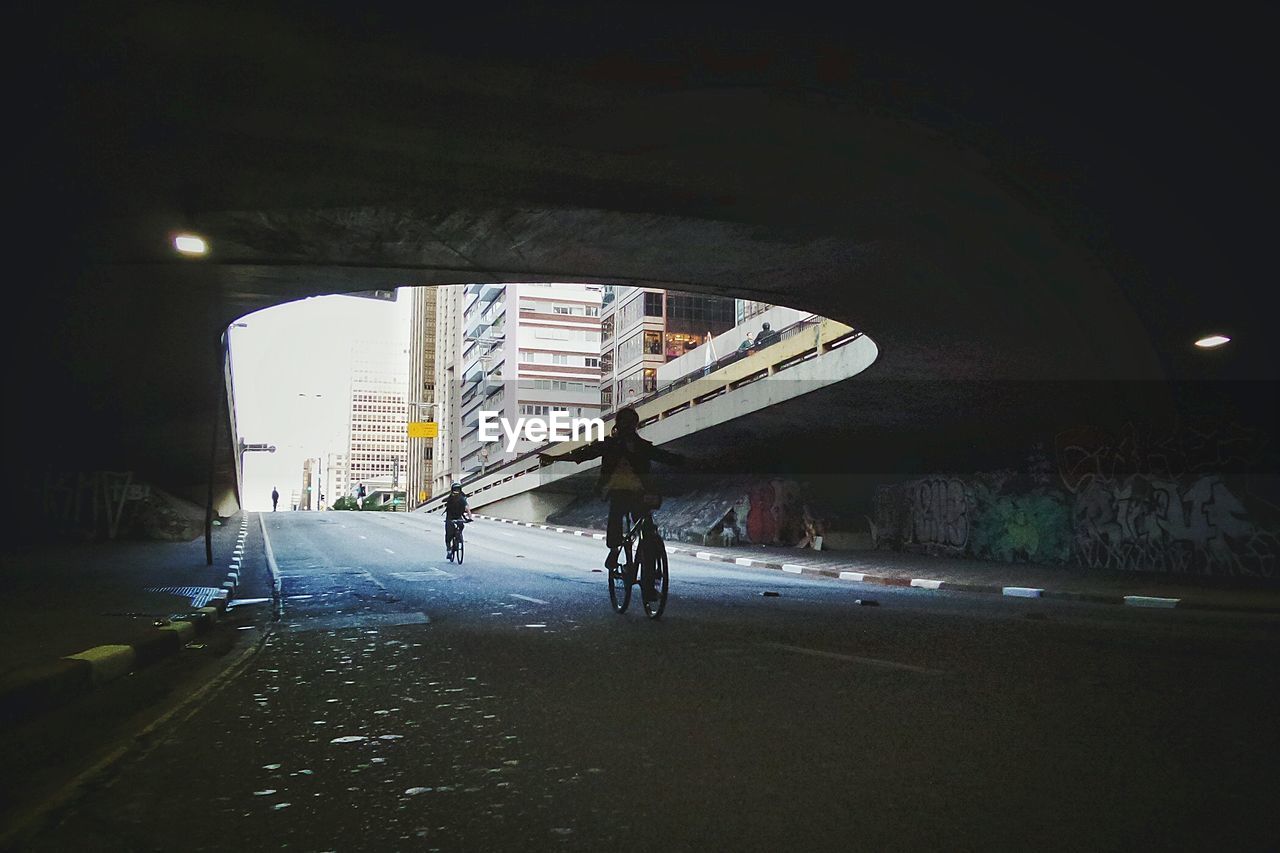 Two people cycling on road