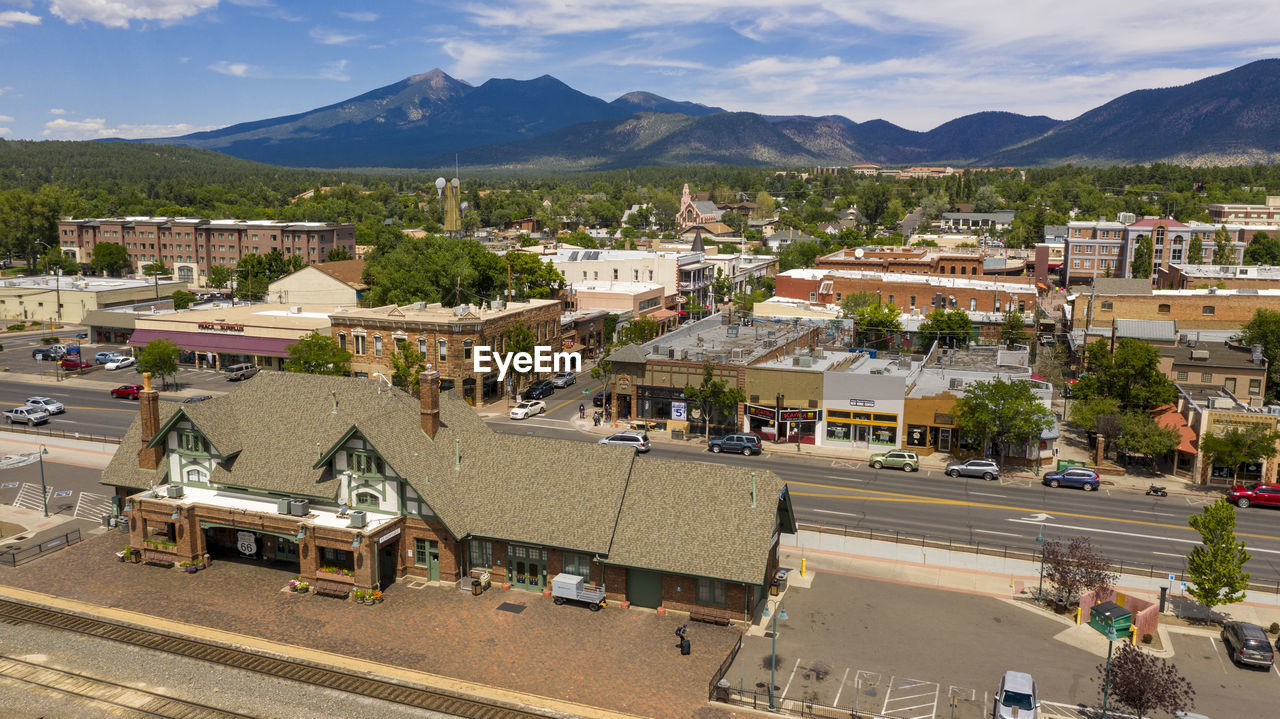 HIGH ANGLE VIEW OF BUILDINGS IN CITY AGAINST MOUNTAINS