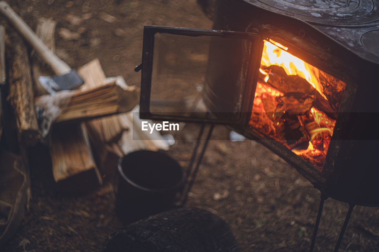 Winter camping. chopping wood with an axe and stoking the wood stove.