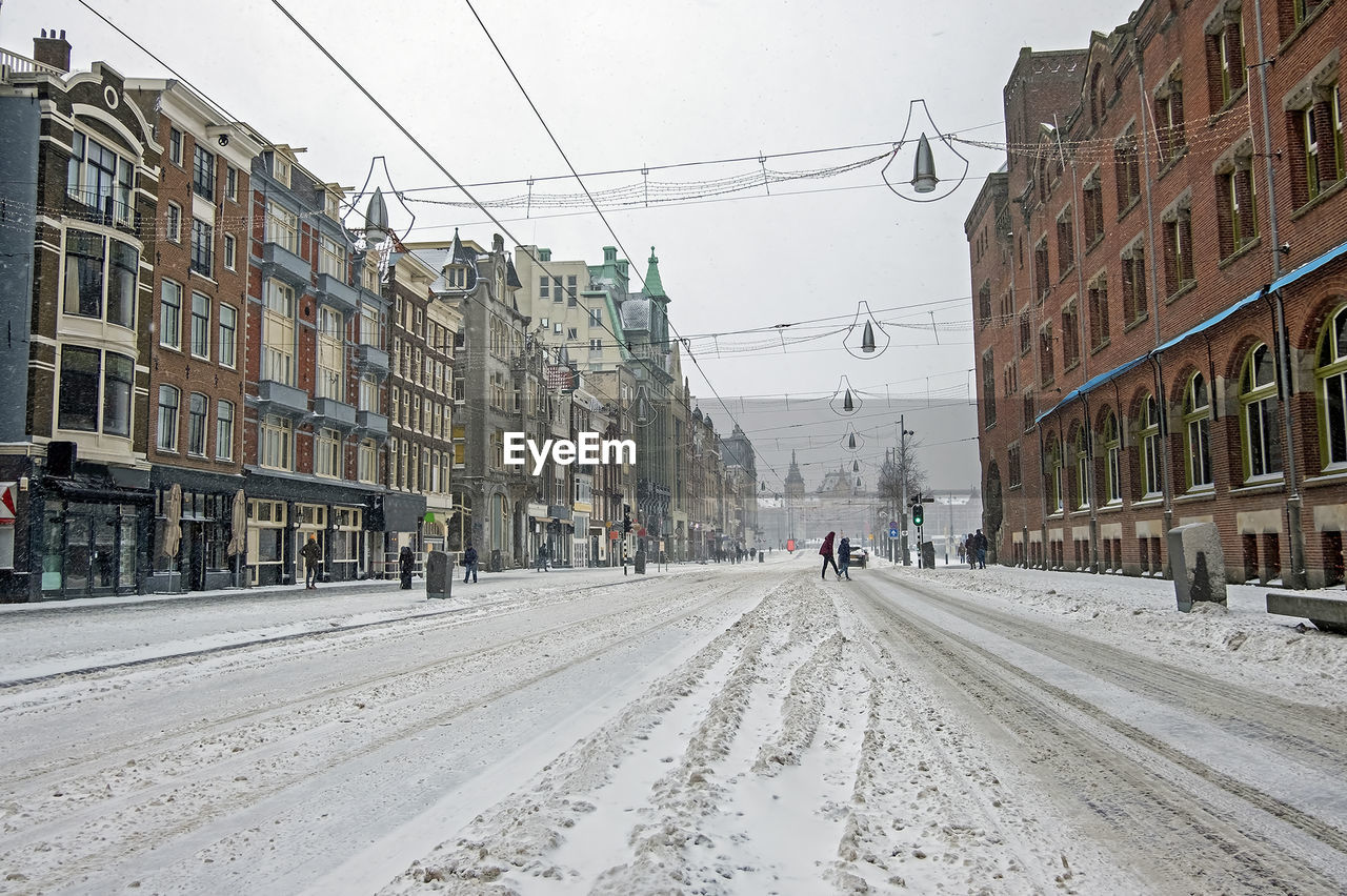 Snowing in amsterdam the netherlands on the damrak in winter