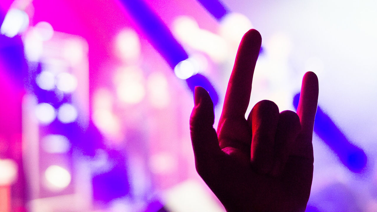 Close-up of hand large group of objects
against illuminated lights