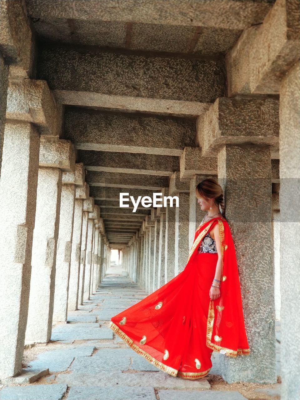 Woman in sari leaning against column
