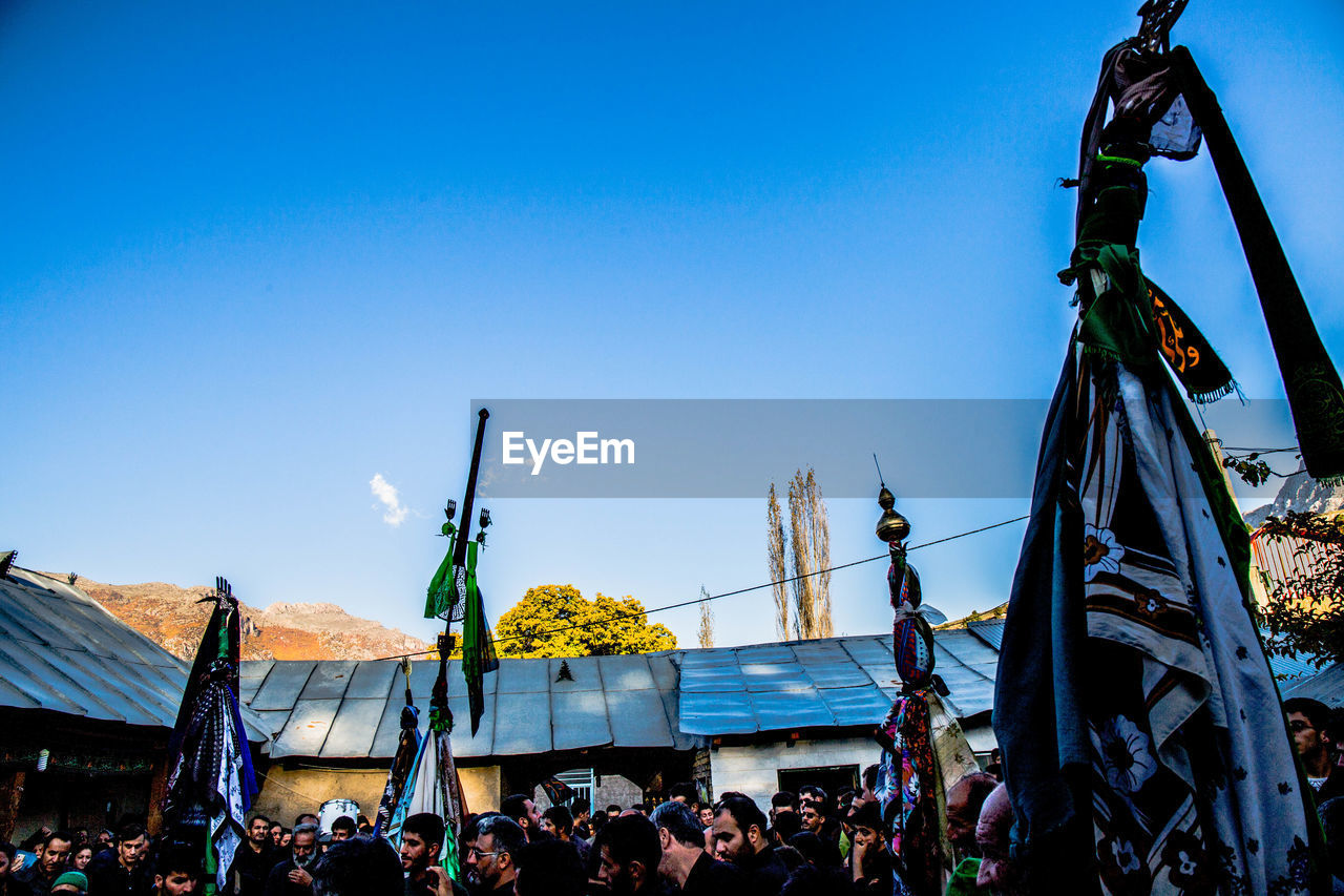 Low angle view of crowd during muharram ceremony against sky