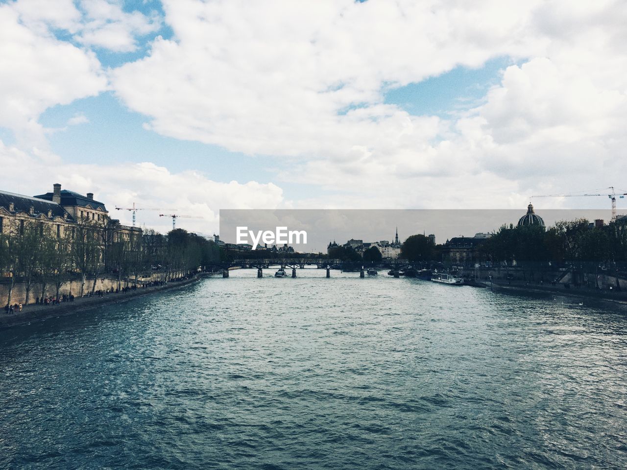 Scenic view of river against sky in city