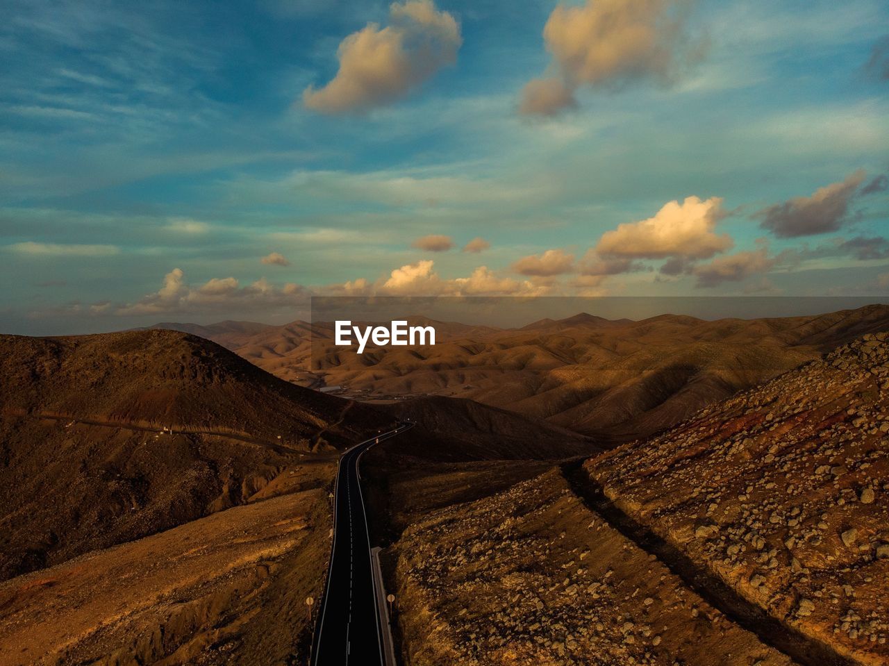 Scenic view of road amidst desert against sky