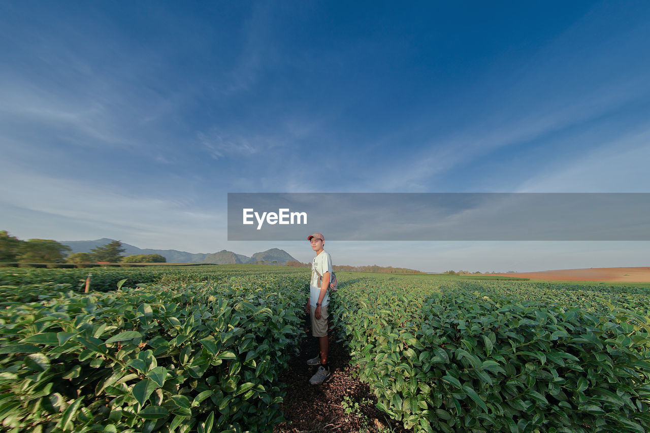 Man standing on field against sky