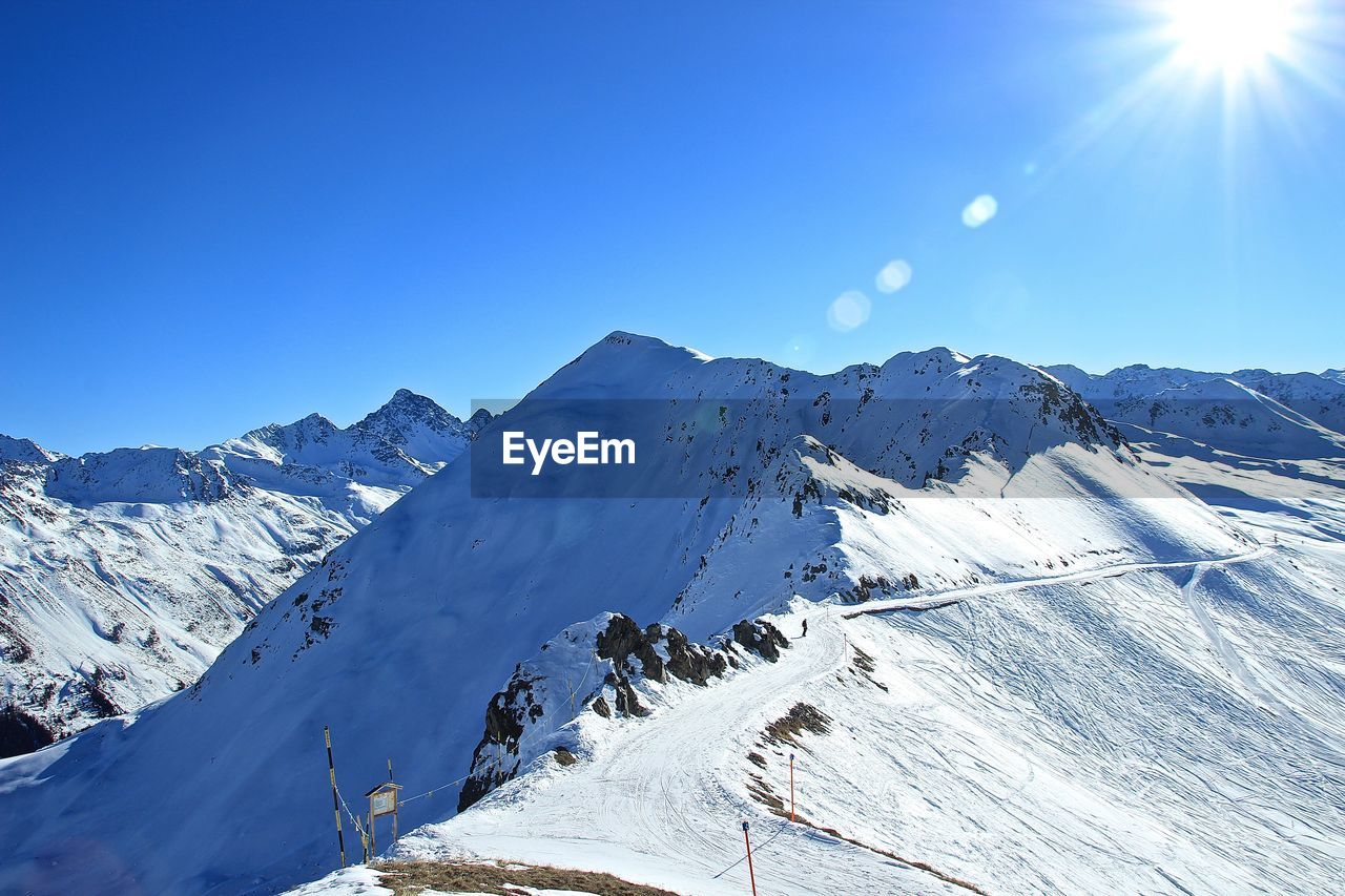 Scenic view of snowcapped mountains against clear blue sky