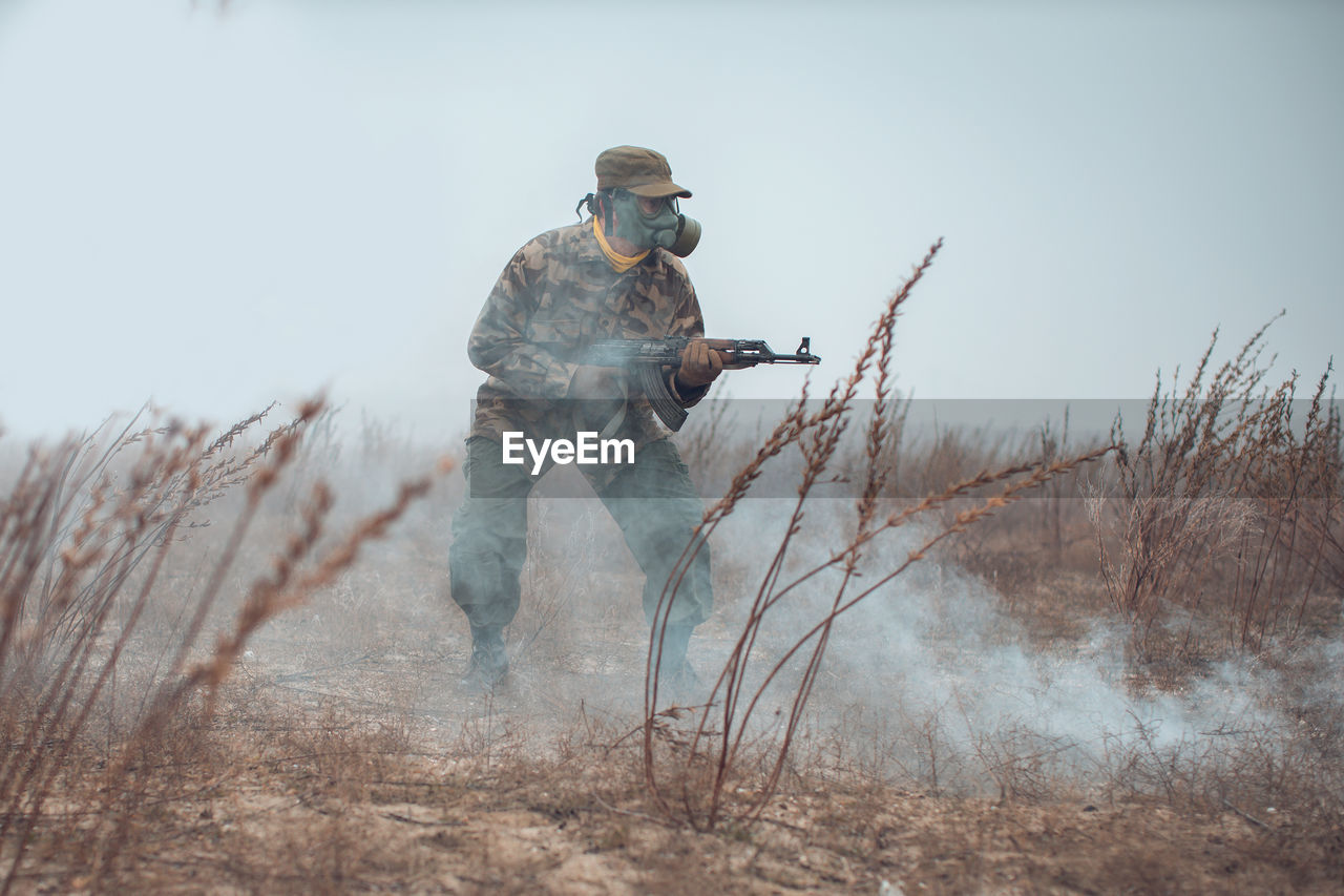 Full length of soldier fighting over snow covered land during winter