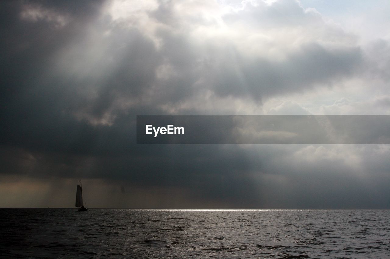 SCENIC VIEW OF SEA AGAINST STORM CLOUD SKY