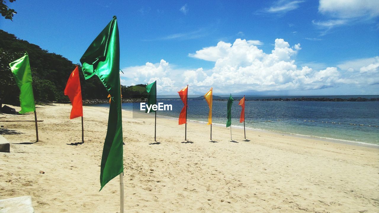 Flags on beach against sky