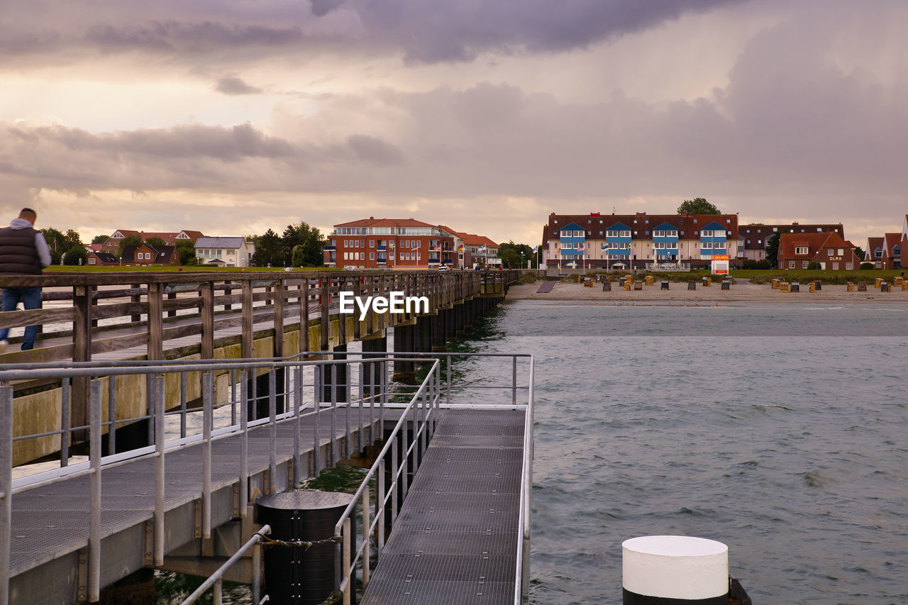 Pier over sea against buildings in city