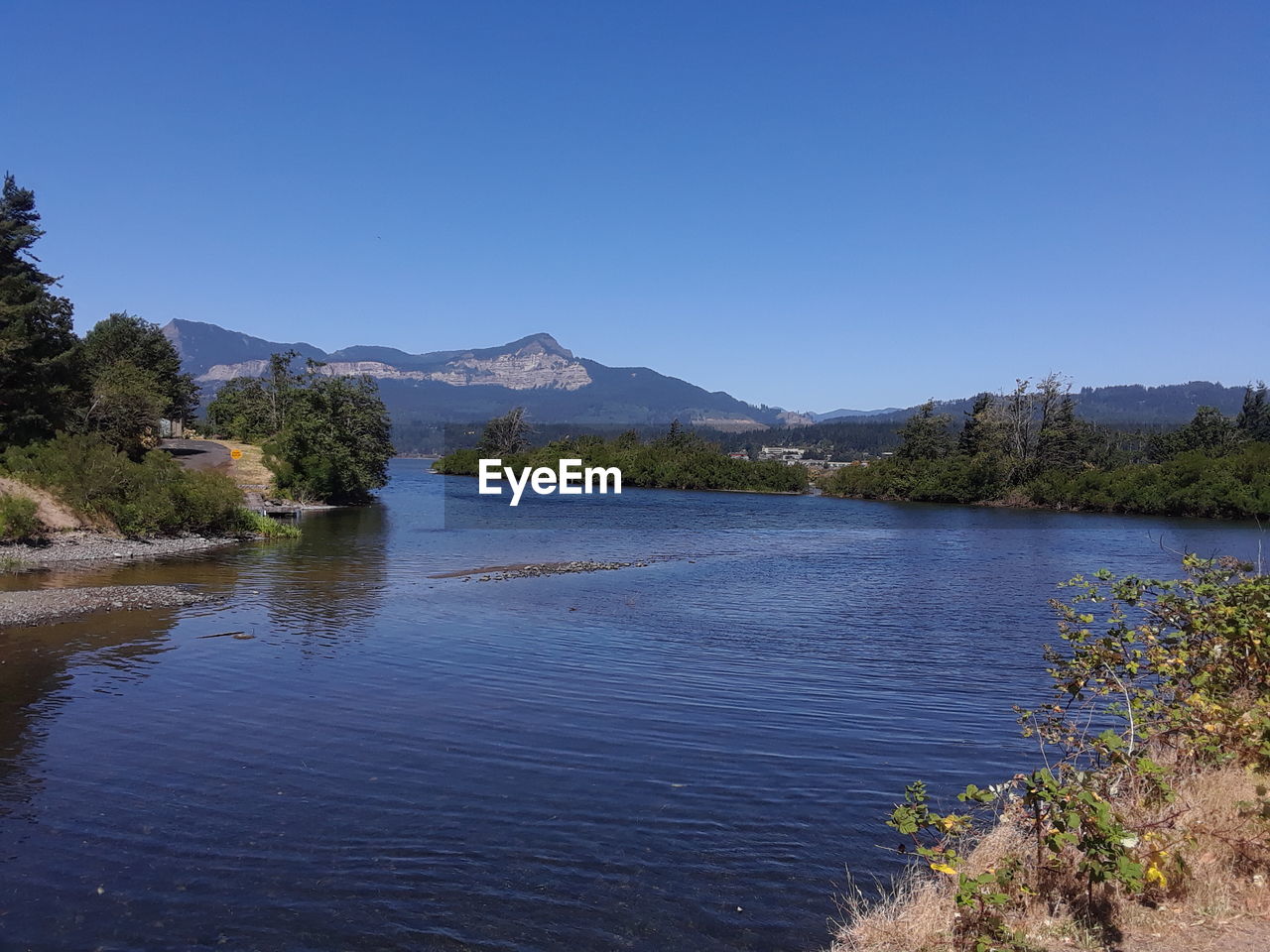 Scenic view of lake against clear blue sky