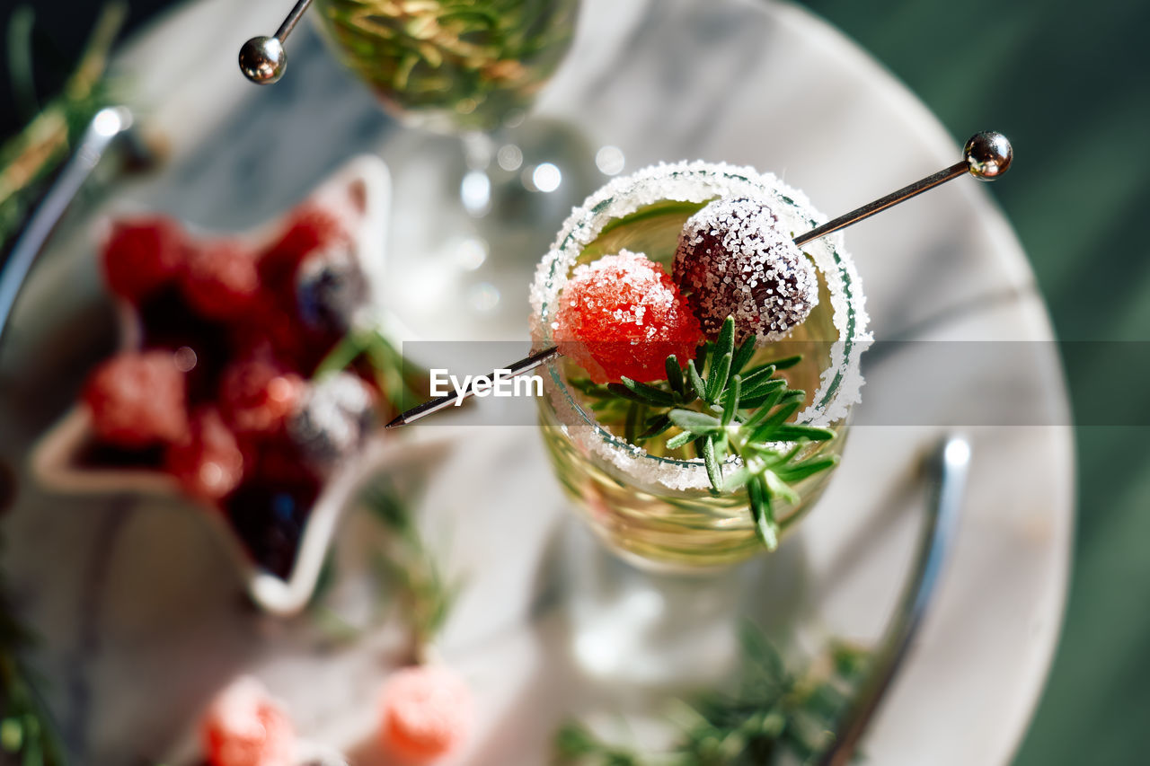 Christmas cocktail with sparkling wine, rosemary and cherry. winter holidays champagne drink.