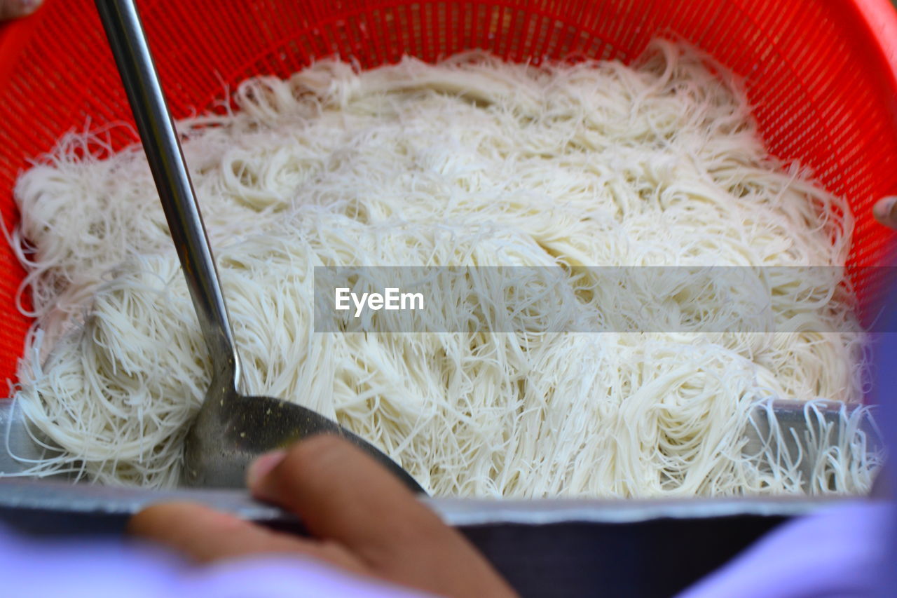 HIGH ANGLE VIEW OF HAND HOLDING BOWL OF KITCHEN