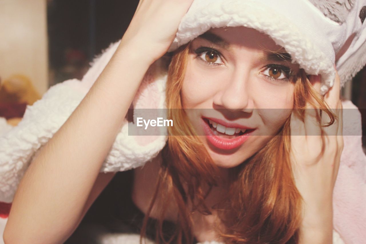 Portrait of beautiful young woman in hat at home