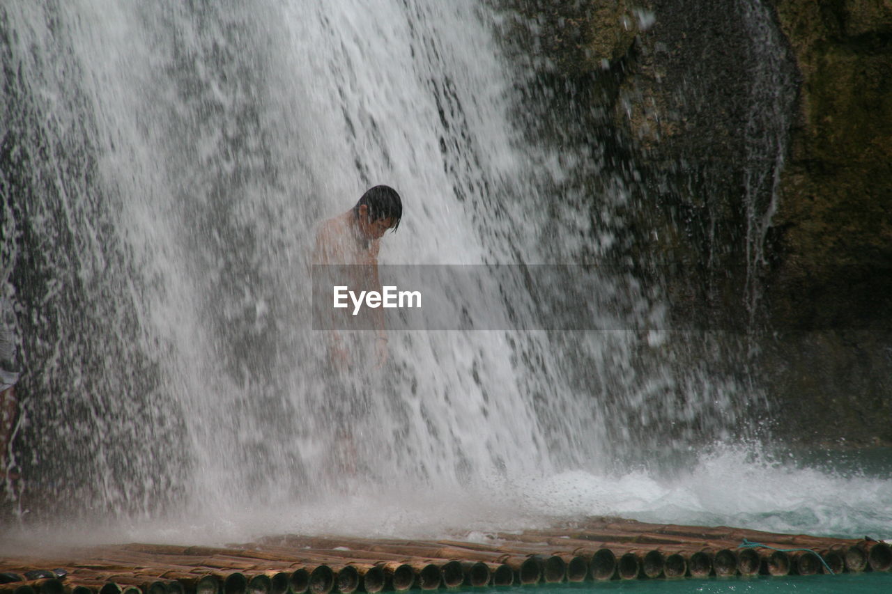 View of person standing in waterfall