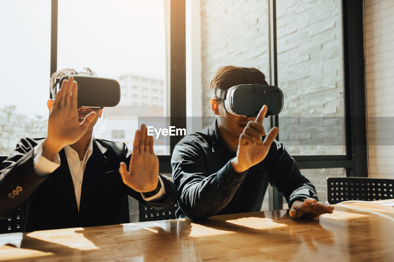 Businessmen wearing virtual reality simulator in office