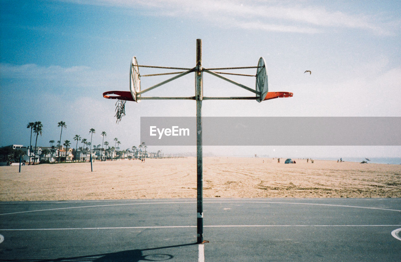 Basketball hoop at beach against sky