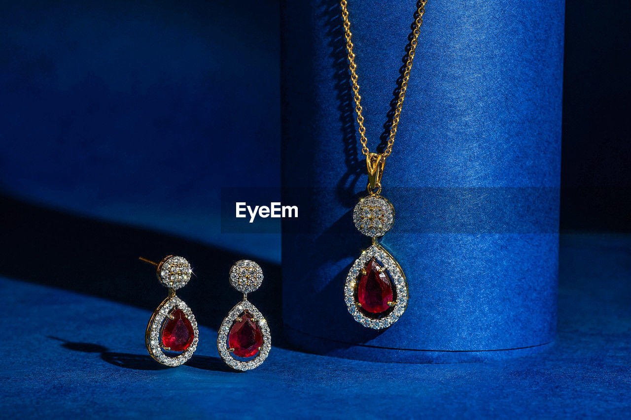 blue, jewelry, necklace, jewellery, fashion accessory, cobalt blue, indoors, no people, chain, fashion, wealth, pendant, close-up, luxury, earring, personal accessory, gold, diamond, metal, still life