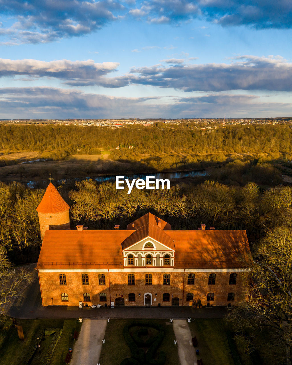 Aerial view of buildings against forest and sky