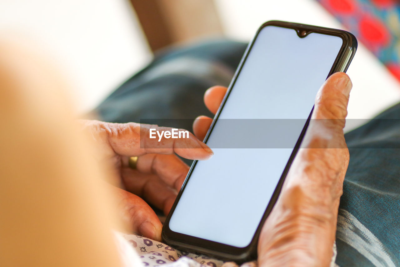 CLOSE-UP OF HAND HOLDING SMART PHONE