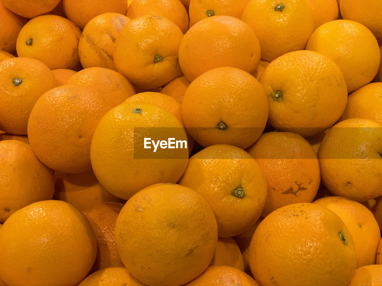 FULL FRAME SHOT OF ORANGES IN MARKET FOR SALE