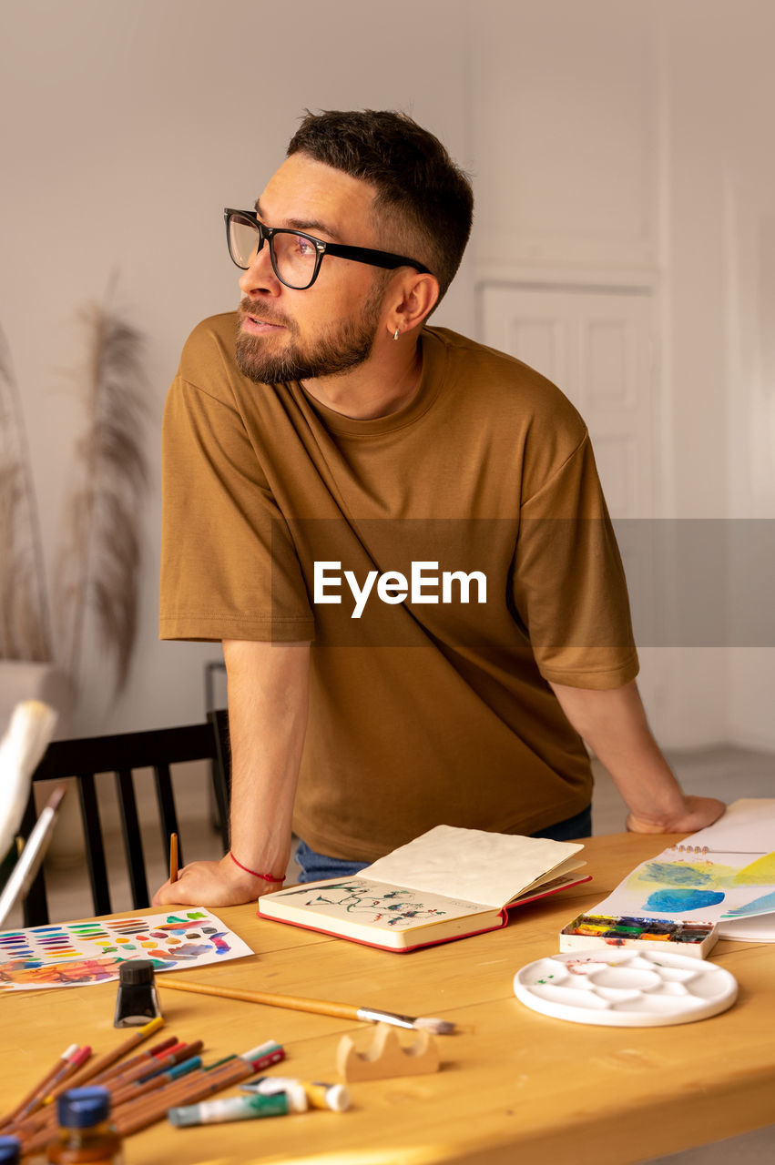 Young man sitting on table at home