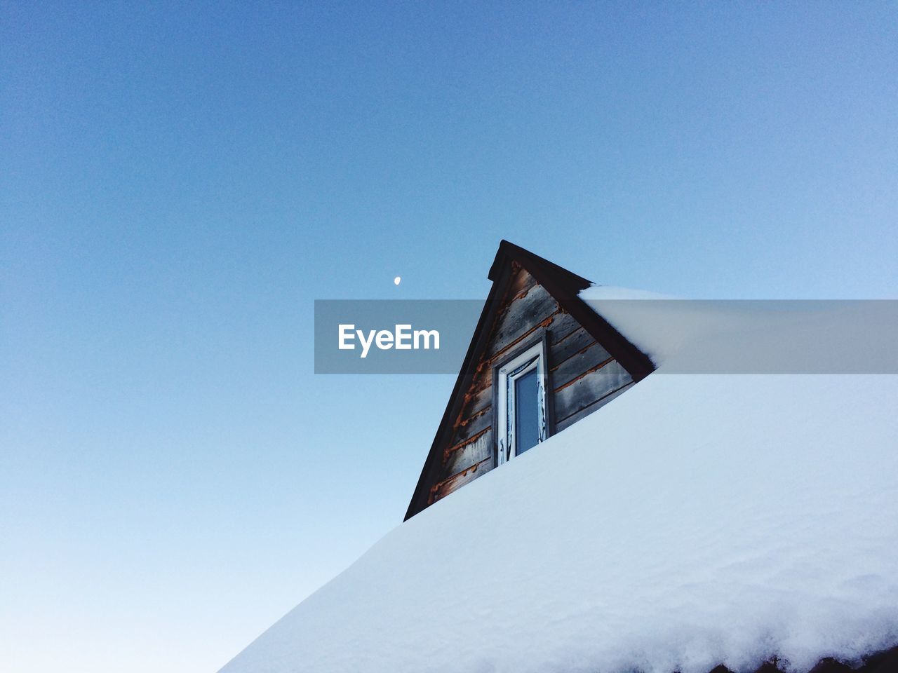 Low angle view of snow covered house against sky 