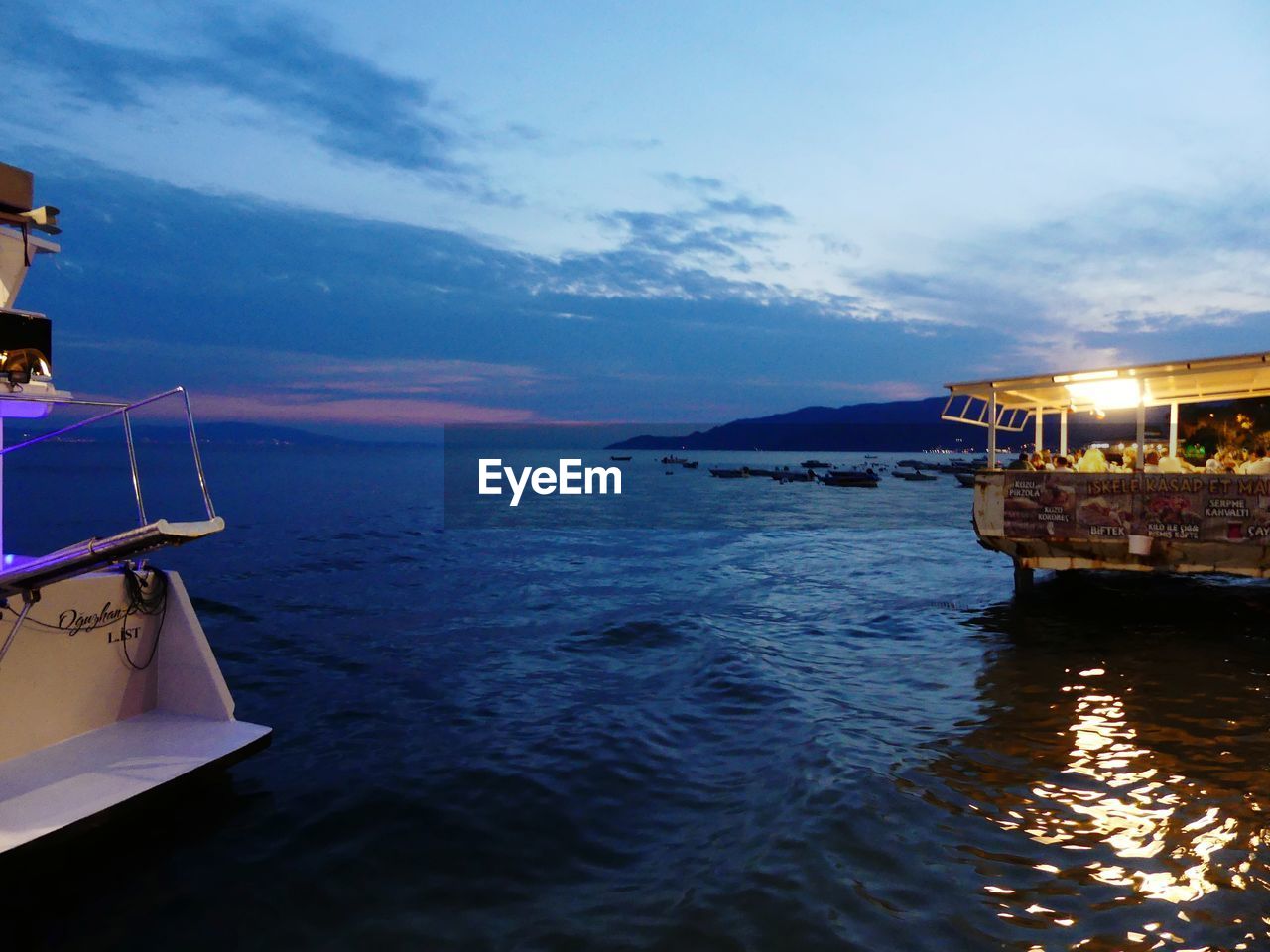 BOATS MOORED IN SEA AGAINST SKY