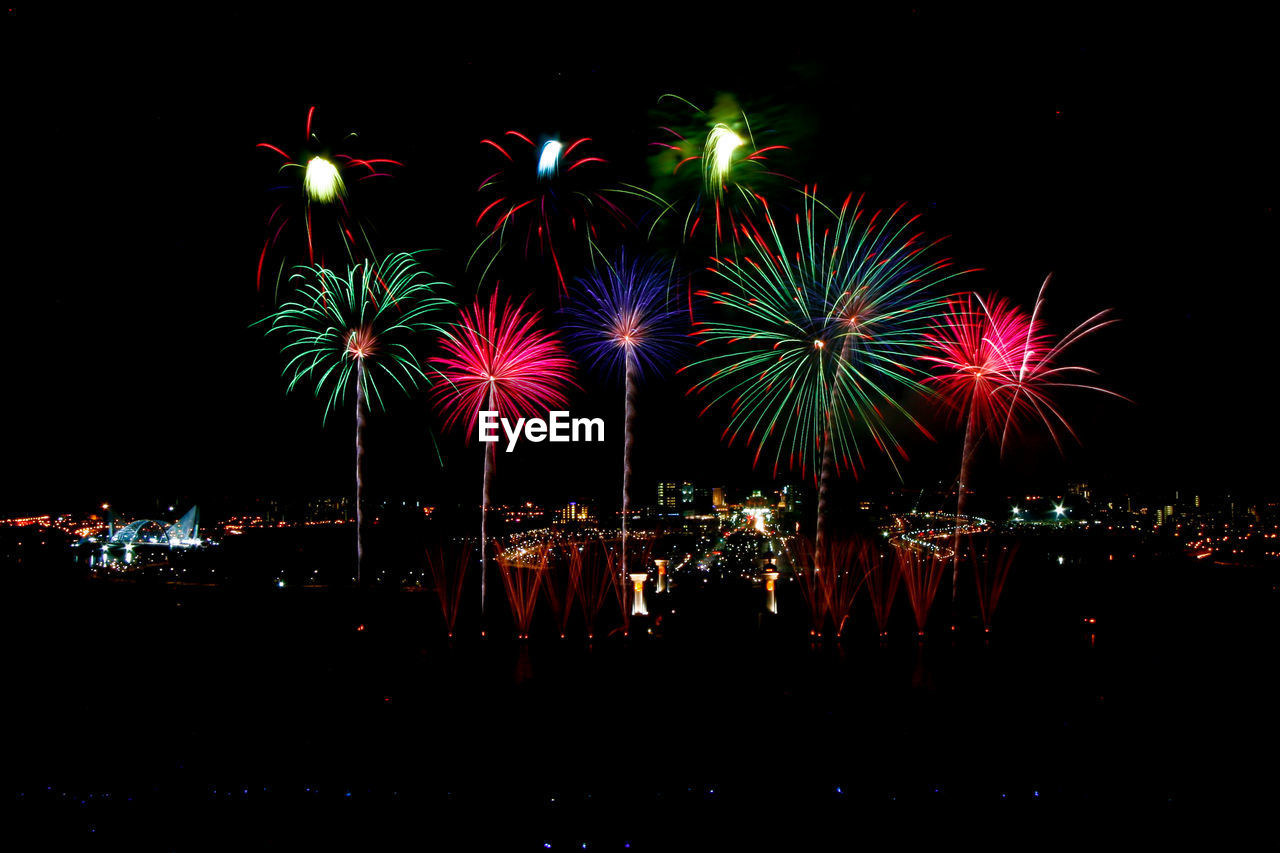 Firework display over illuminated city at night