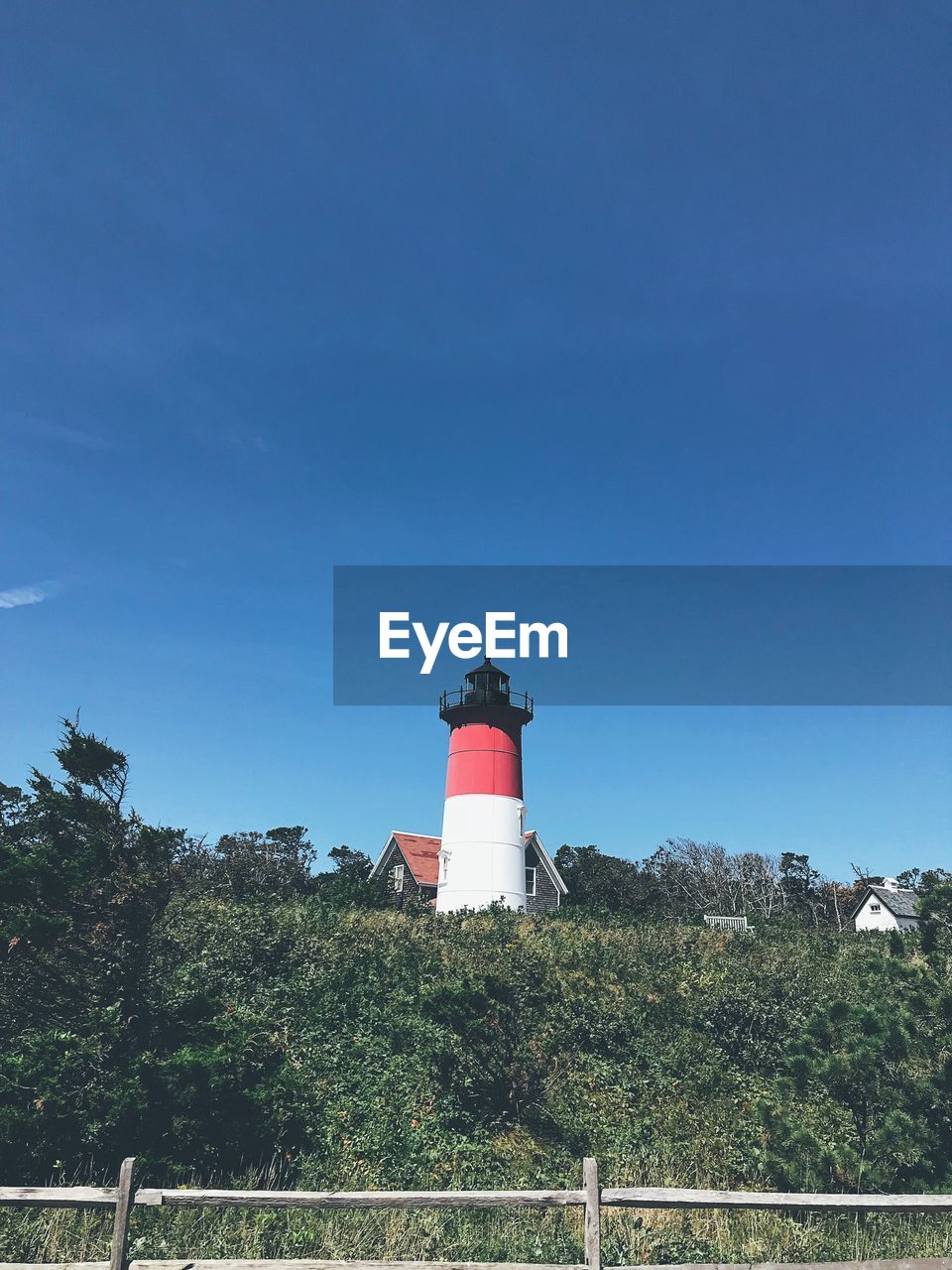 LOW ANGLE VIEW OF LIGHTHOUSE AGAINST BUILDINGS AND SKY