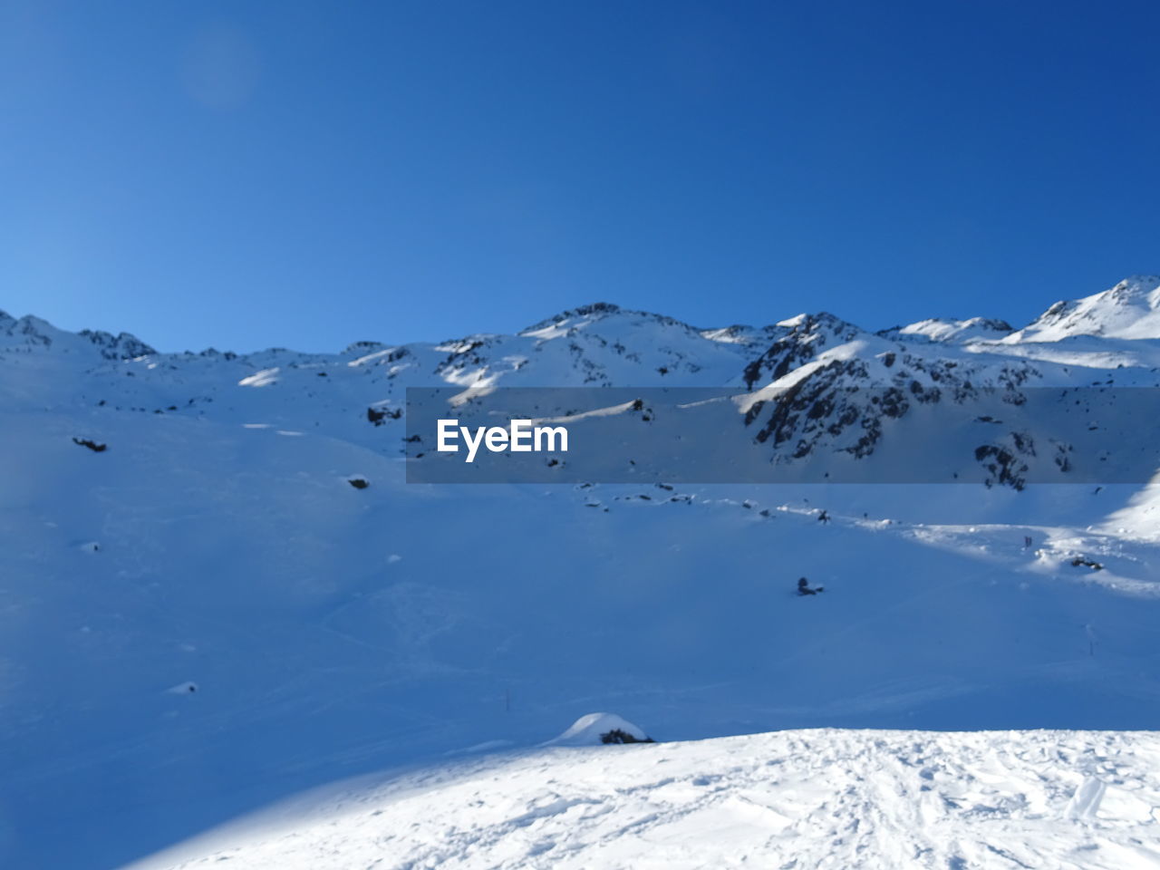 SCENIC VIEW OF SNOWCAPPED MOUNTAINS AGAINST BLUE SKY