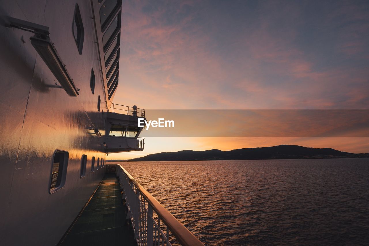 Boat on sea against sky during sunset