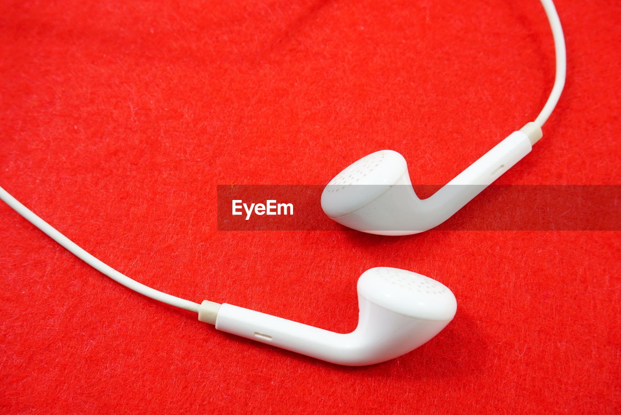 White earphone isolated on red background