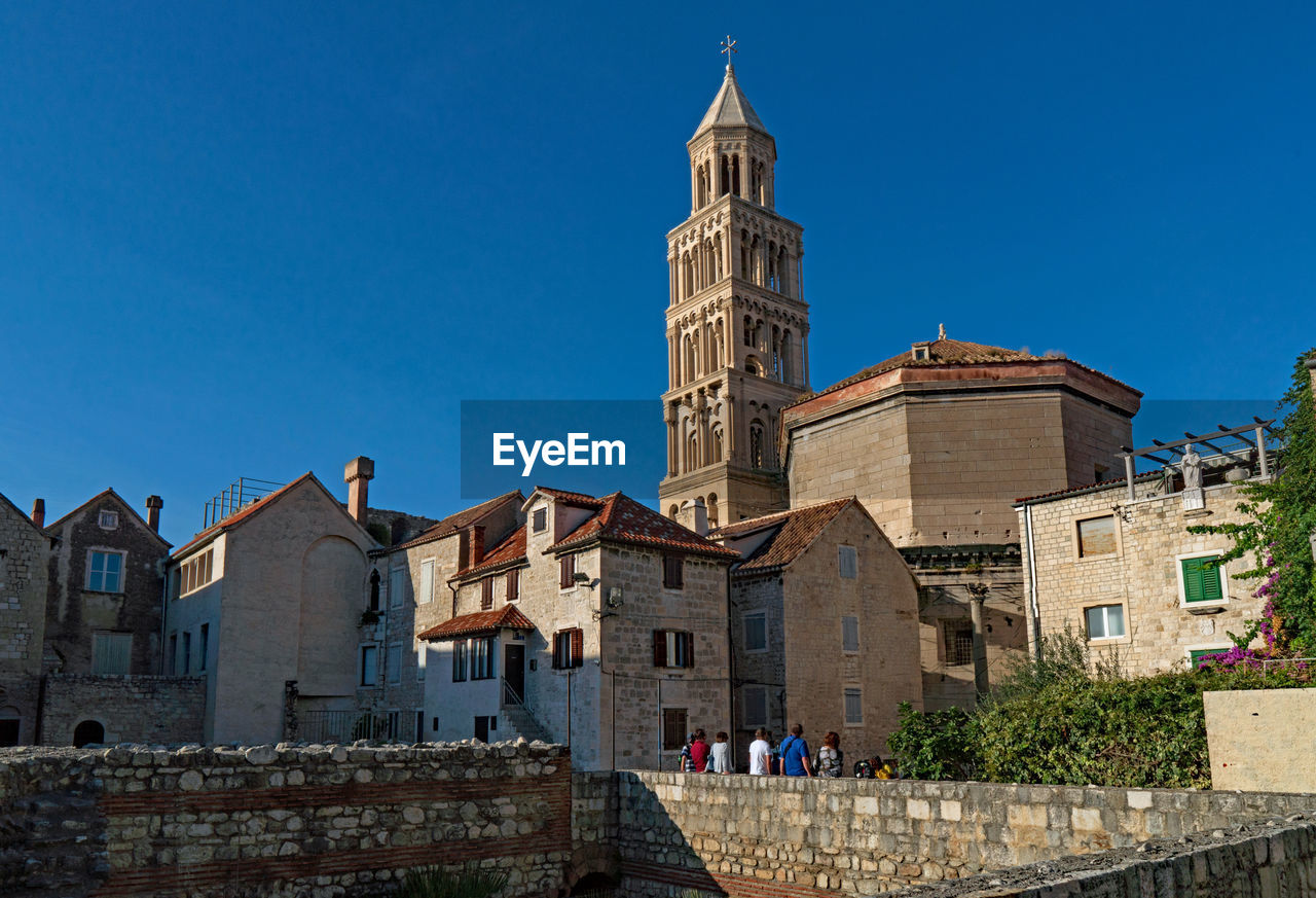 Low angle view of buildings against clear blue sky