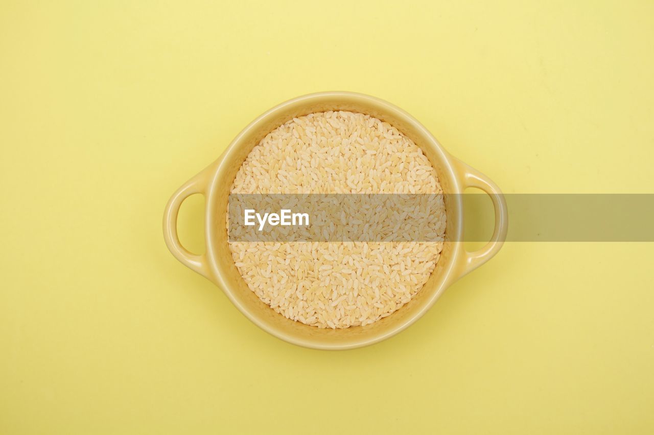 Sterlline raw pasta on a yellow bowl on yellow background