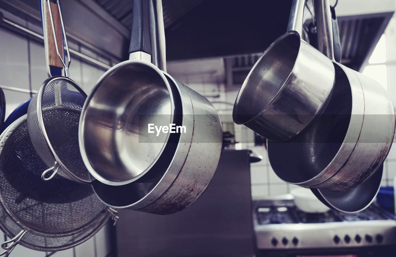 Close-up of colanders with saucepans in kitchen