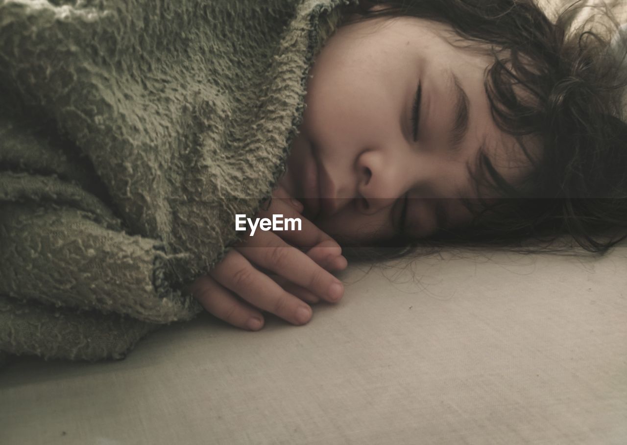 Close-up of baby sleeping on bed