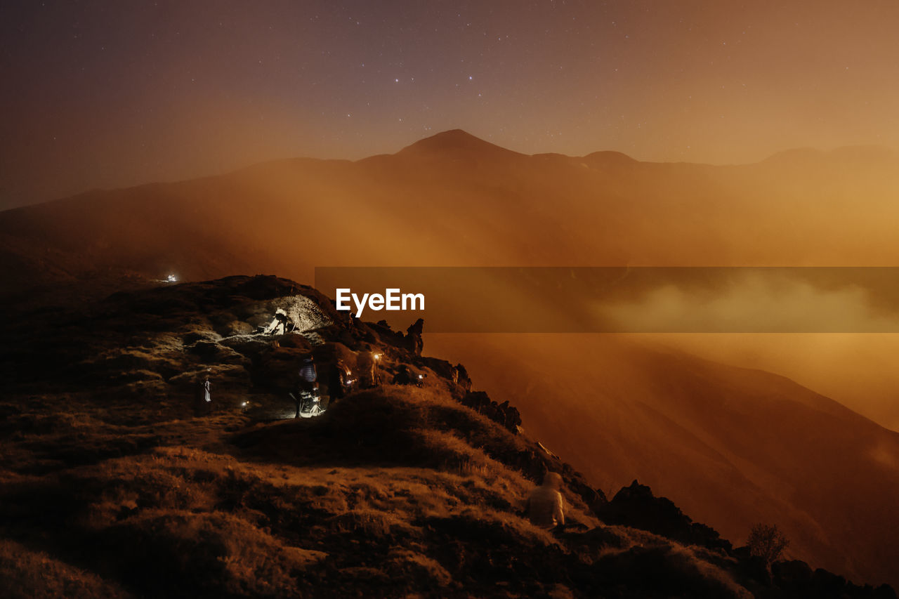 Scenic view of mountains against sky at night