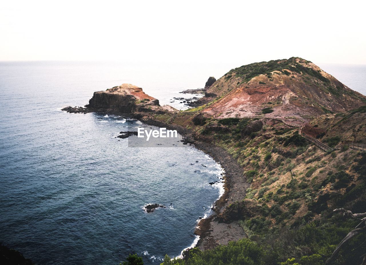 HIGH ANGLE VIEW OF ROCK FORMATION IN SEA AGAINST SKY