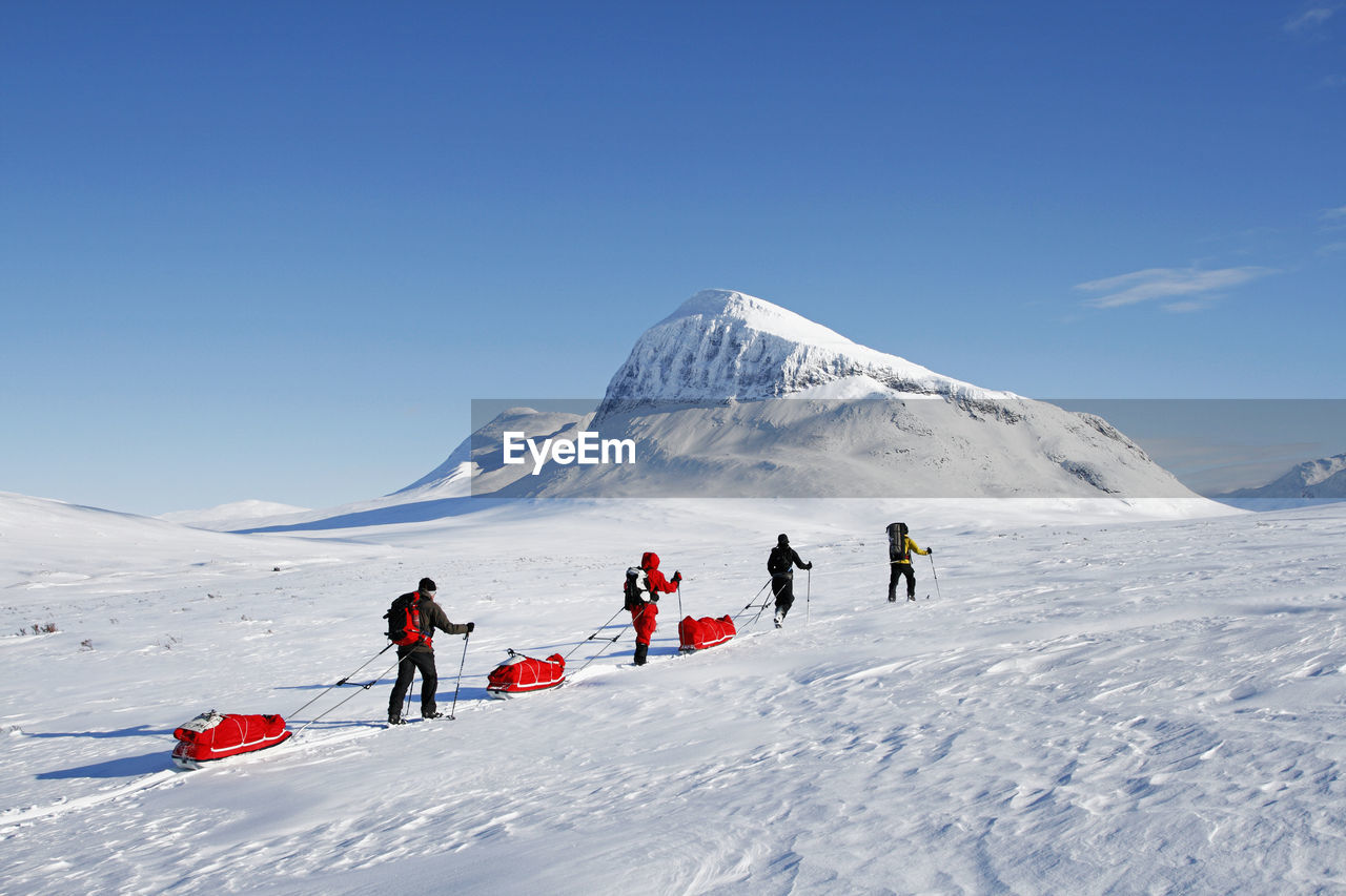 Tourists cross country skiing against mountain scenery