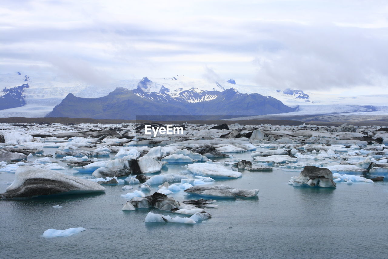 SCENIC VIEW OF FROZEN LAKE AGAINST MOUNTAIN