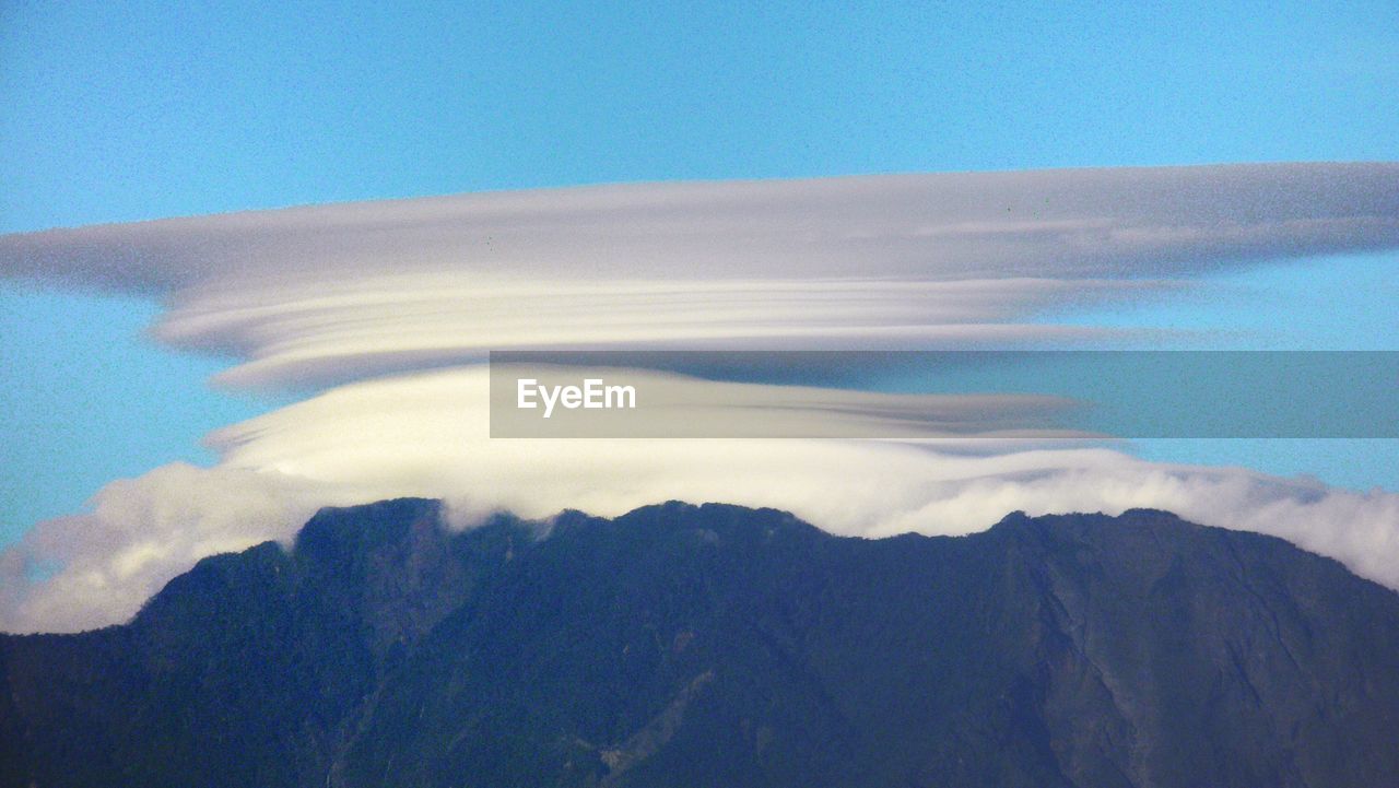 Scenic view of mountains against blue sky