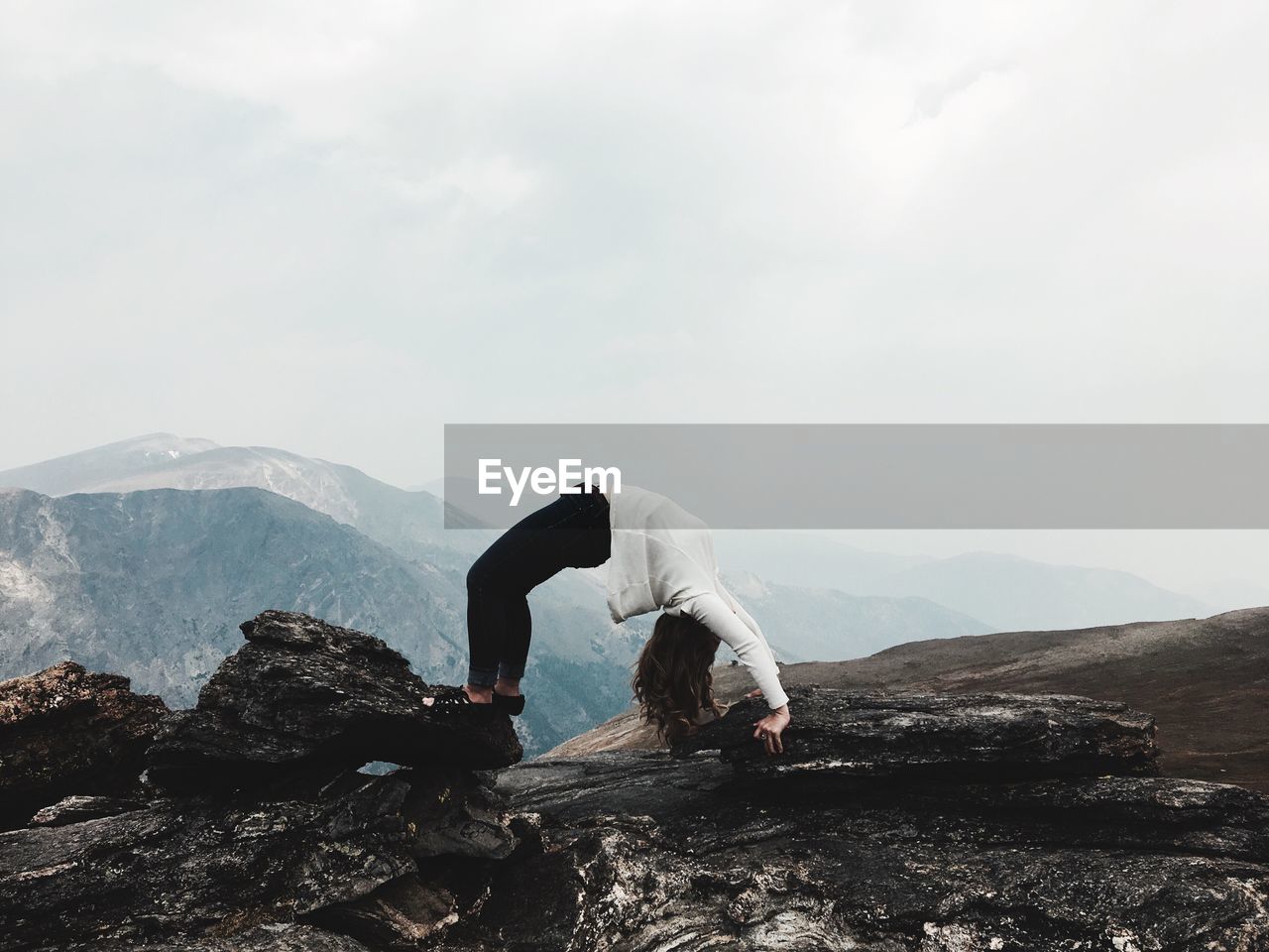 Woman standing on mountain against sky