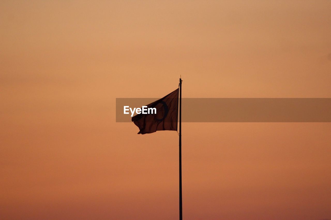 Low angle view of turkish flag against orange sky