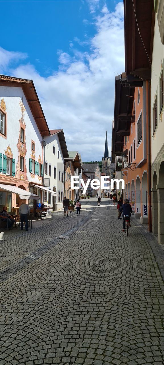 PEOPLE ON STREET AMIDST BUILDINGS IN TOWN